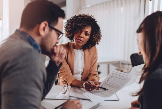 Women-Holding-Documents-and-Showing-Her-Male-and-Female-Clients-A-Section